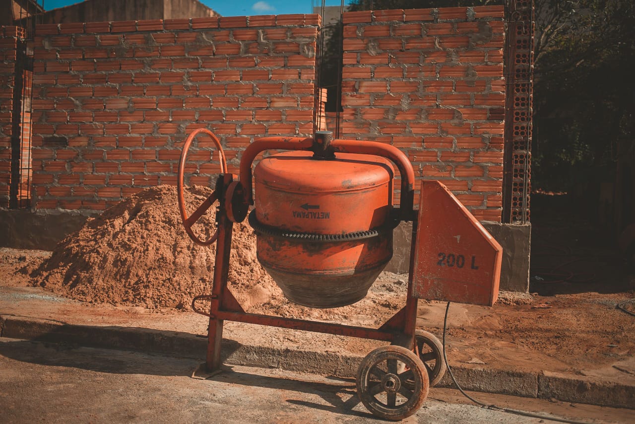 Concrete mixer and sand pile in front of a new brick boundary wall