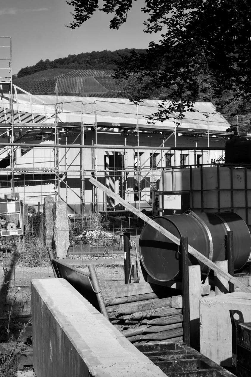 Scaffolding around a building with roof works in progress and site storage tanks