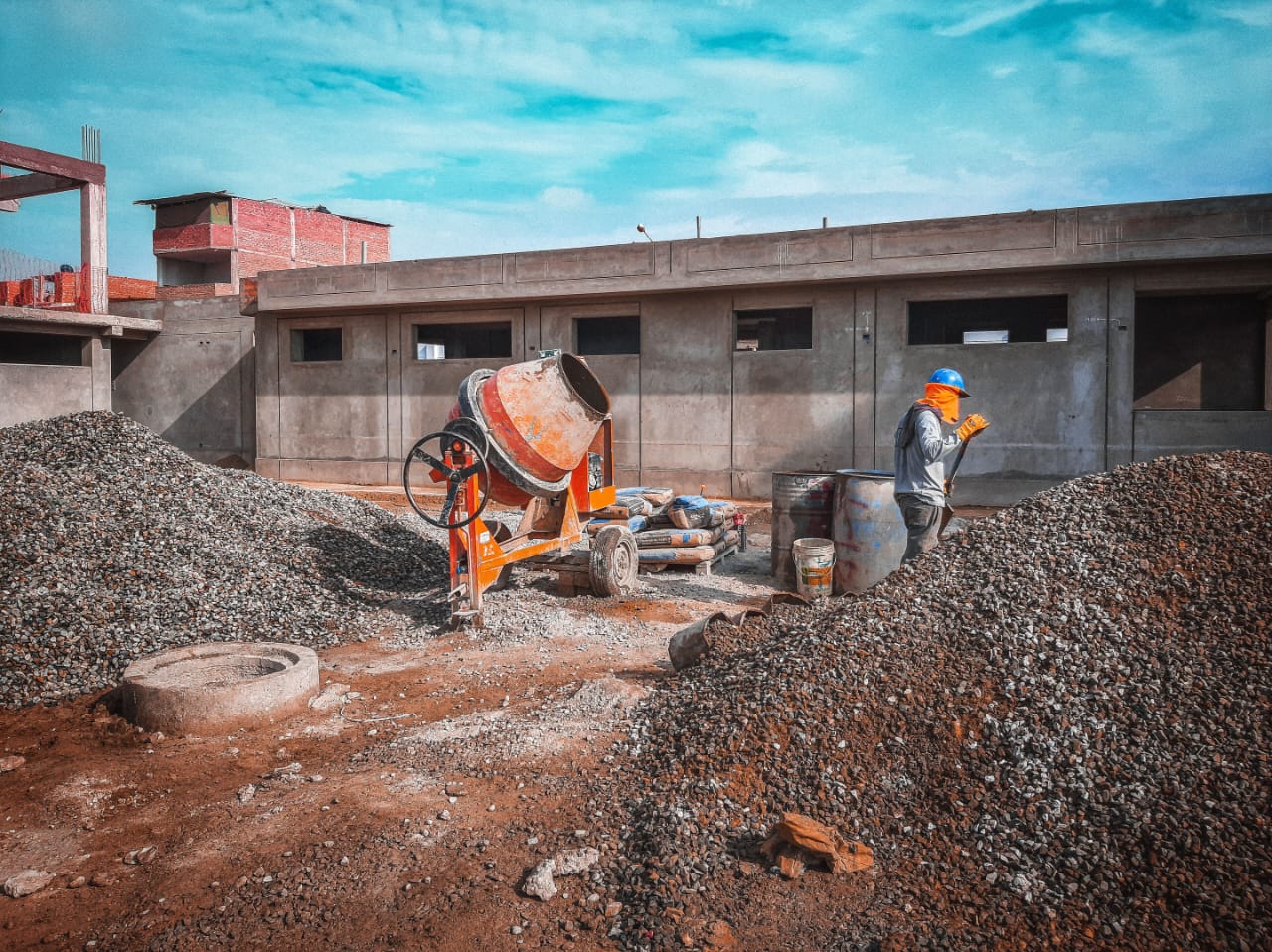 Long single-storey classroom block under construction with materials on site